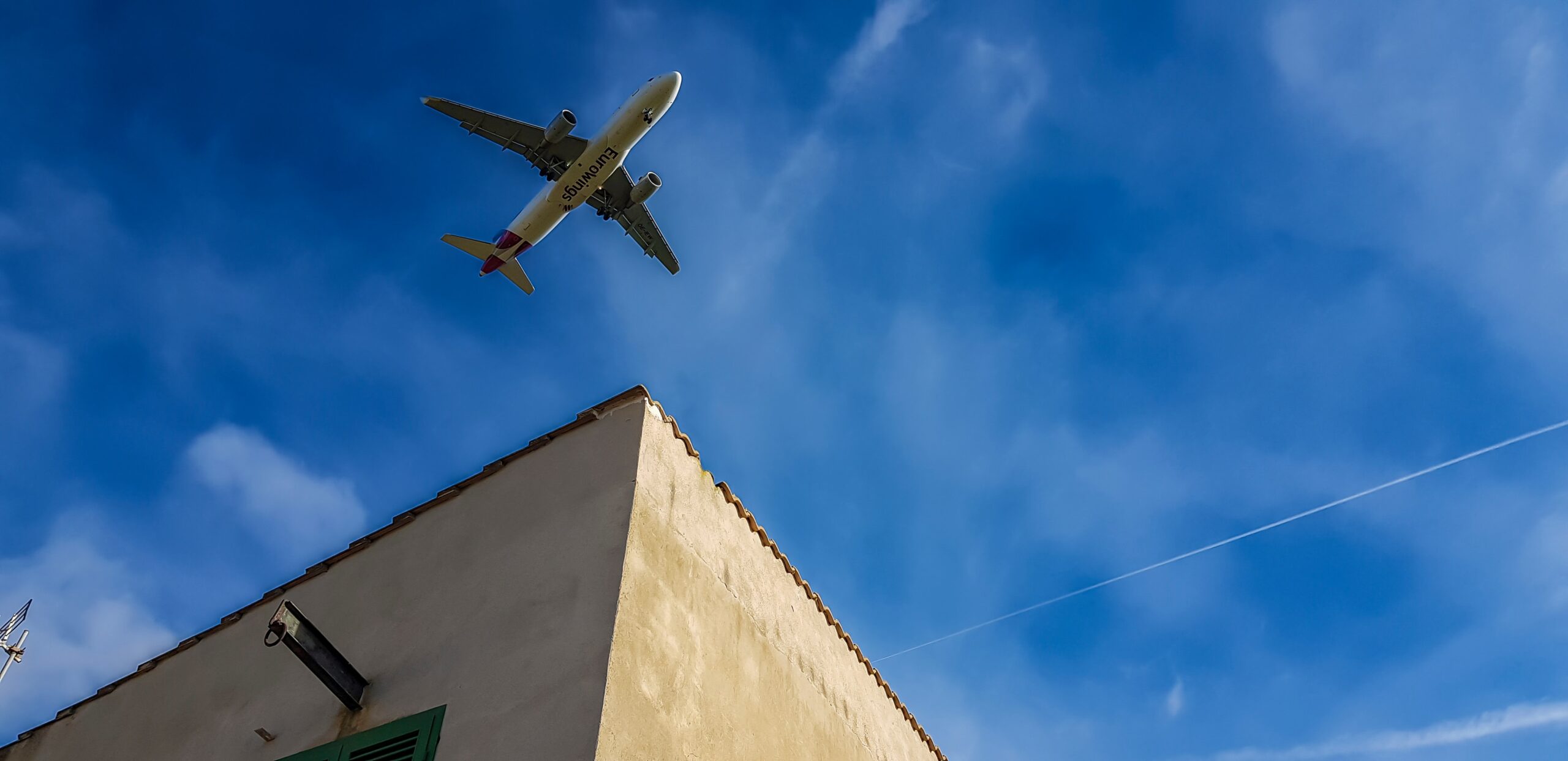 Airplane flying overhead above a building