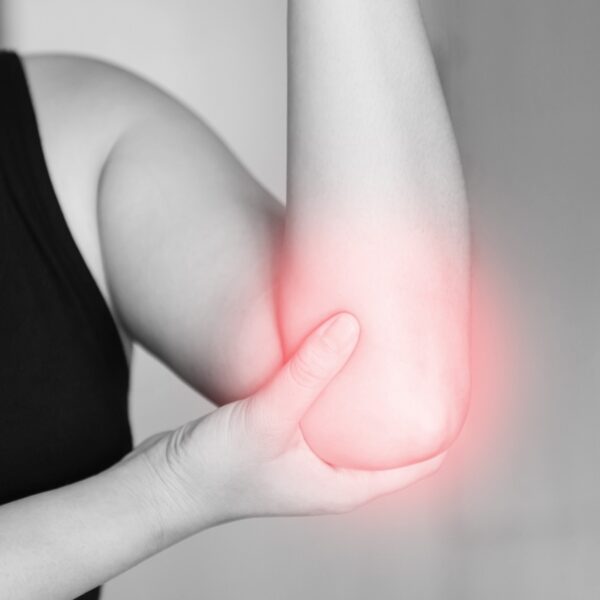 Grayscale photo of a person with injured elbow. The elbow looks like it has a faint red glow.
