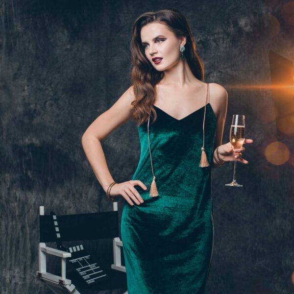 Woman in a green dress holding a glass of Champagne