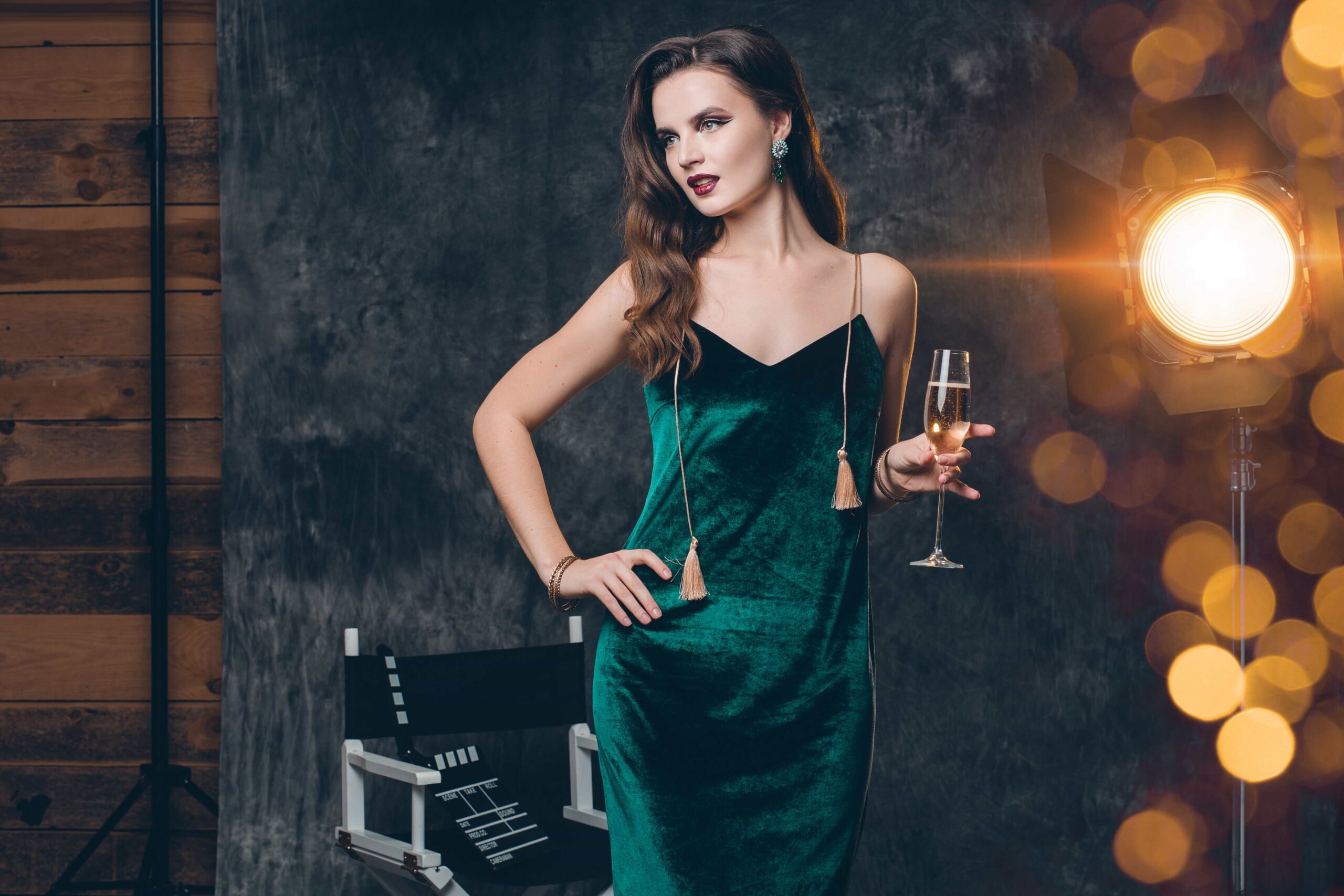 Woman in a green dress holding a glass of Champagne