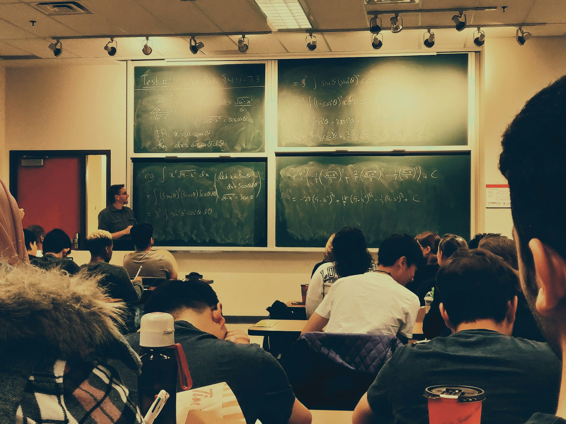 A classroom full of students with math equations on the board